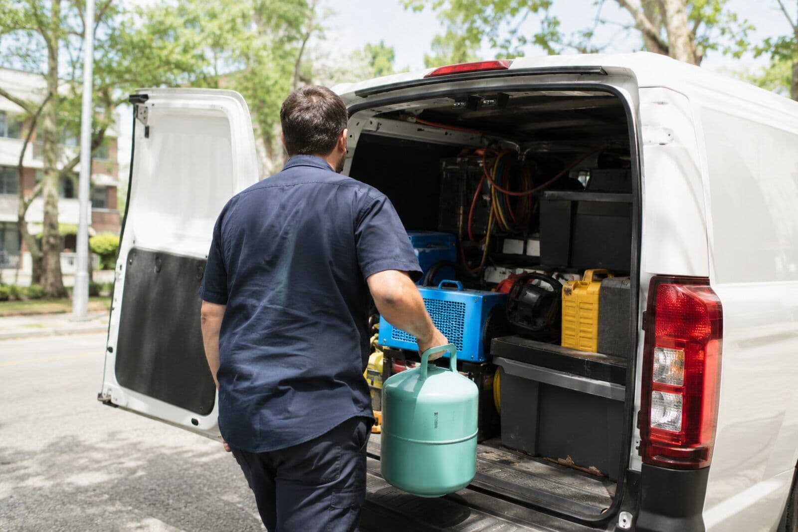 Frigoriste de Zéphyr Clim chargeant une bouteille de fluide à l’arrière du véhicule d’intervention